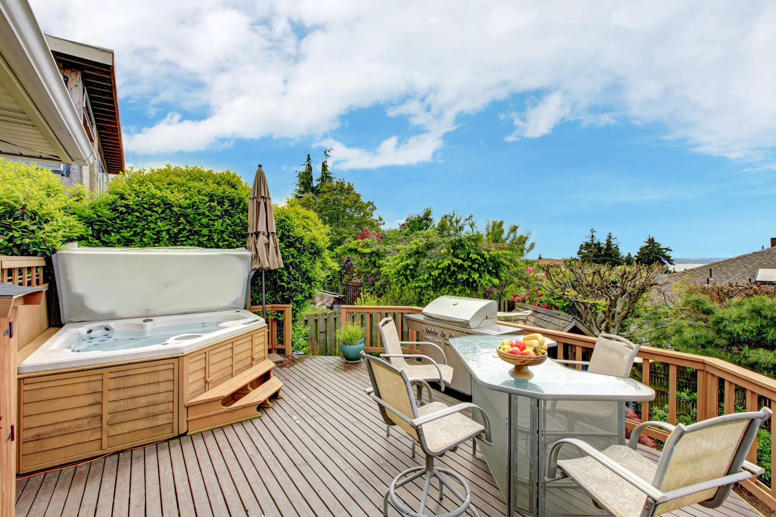 Beautiful walkout deck with hot tub , patio table set and barbecue